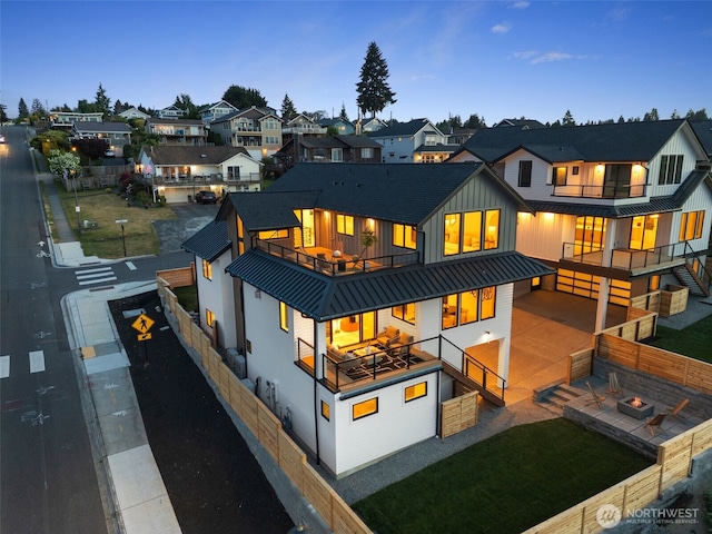 rear view of house featuring a balcony, a standing seam roof, stairway, and metal roof