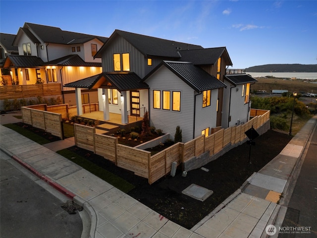 view of front facade with board and batten siding, a standing seam roof, a vegetable garden, metal roof, and a mountain view