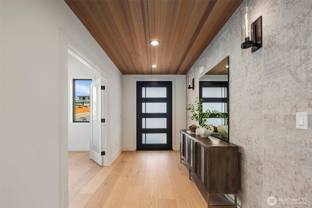 foyer entrance featuring light wood finished floors, recessed lighting, wood ceiling, plenty of natural light, and baseboards