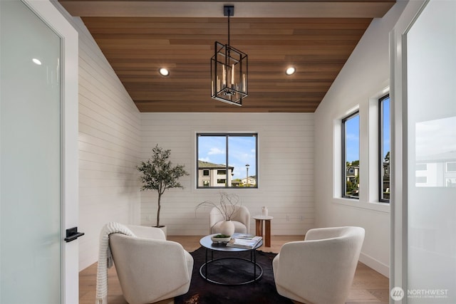 living area featuring lofted ceiling, wood ceiling, recessed lighting, wood finished floors, and a chandelier