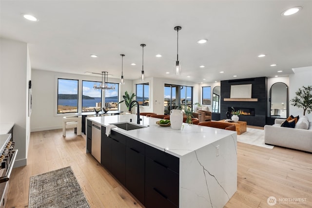 kitchen featuring dark cabinets, a sink, modern cabinets, a large island, and recessed lighting