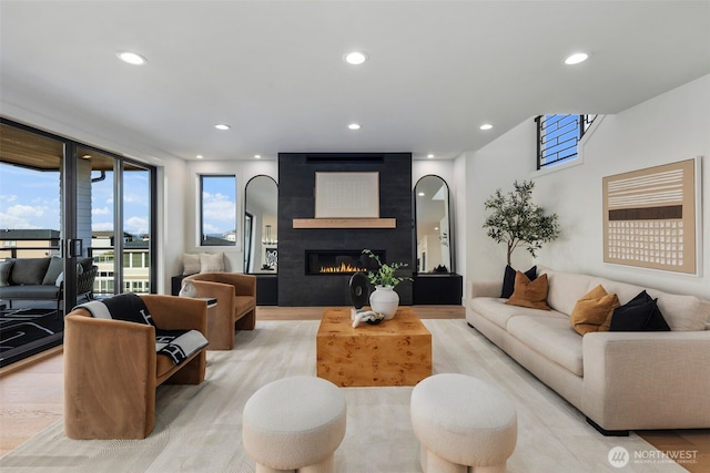 living room with recessed lighting, light wood-style flooring, and a fireplace