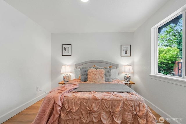 bedroom with baseboards and wood finished floors