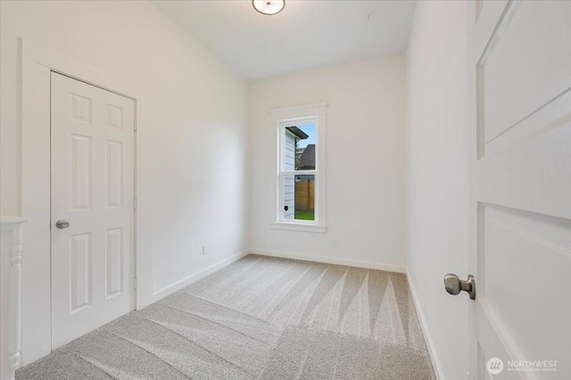 empty room with light colored carpet and baseboards