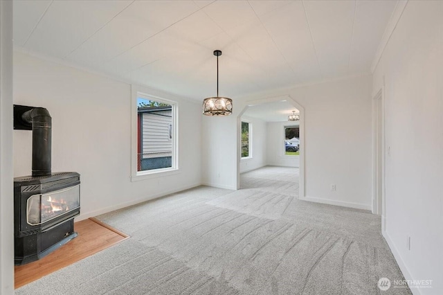 unfurnished living room with carpet flooring, plenty of natural light, and baseboards