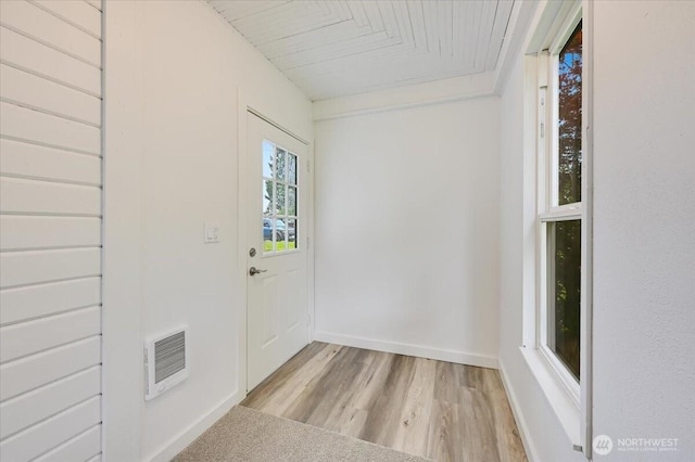 doorway featuring light wood-style flooring, baseboards, and wood ceiling