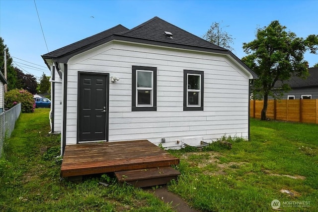rear view of property with roof with shingles