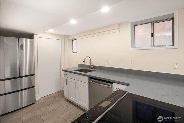 816 N 43rd St, Seattle, WA 98103 - kitchen with stainless steel appliances, a sink, white cabinets, dark countertops, and recessed lighting