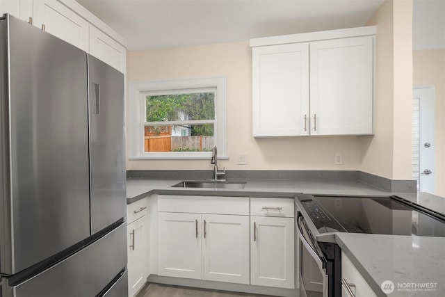 816 N 43rd St, Seattle, WA 98103 - kitchen featuring freestanding refrigerator, electric range, a sink, and white cabinetry
