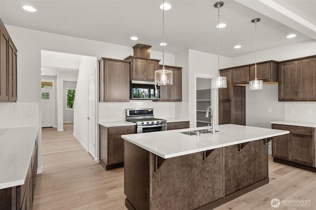 2880 75th Ave SW Lot 62, Tumwater, WA 98512 - kitchen with stainless steel appliances, light wood-style floors, a kitchen bar, light countertops, and decorative light fixtures