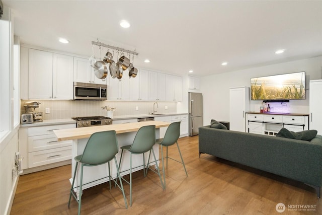 341 NW 90th St Unit B, Seattle, WA 98117 - kitchen featuring stainless steel appliances, butcher block counters, a sink, white cabinets, and recessed lighting