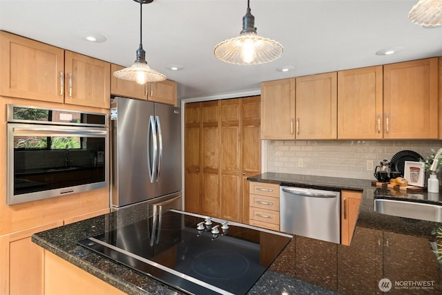 kitchen with appliances with stainless steel finishes, backsplash, decorative light fixtures, a sink, and recessed lighting