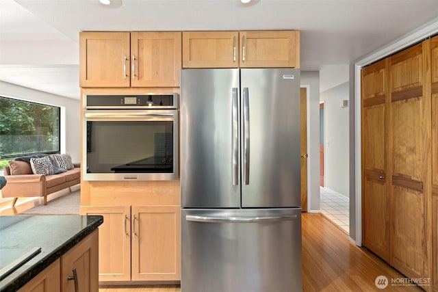 kitchen featuring appliances with stainless steel finishes, light brown cabinetry, and light wood-style floors
