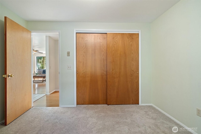 unfurnished bedroom featuring carpet, a closet, and baseboards