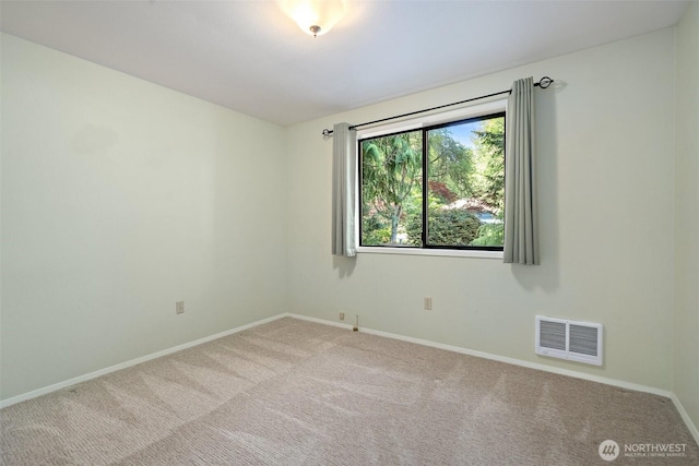 carpeted empty room featuring baseboards