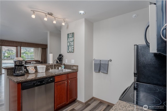 kitchen with dishwasher, a sink, light wood-type flooring, a peninsula, and stove