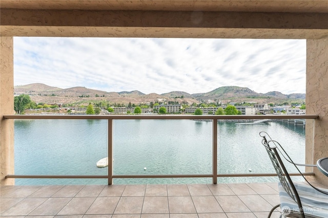 balcony featuring a water and mountain view