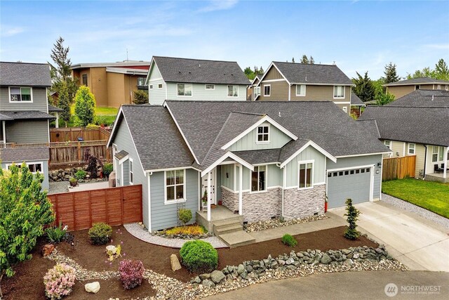 6068 Monument Dr, Ferndale, WA 98248 - view of front facade featuring board and batten siding, fence, driveway, a garage, and a residential view