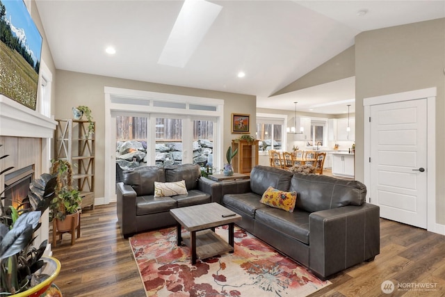 6068 Monument Dr, Ferndale, WA 98248 - living area with a fireplace, dark wood-type flooring, lofted ceiling, recessed lighting, and a skylight