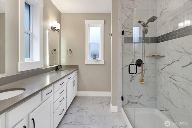 6068 Monument Dr, Ferndale, WA 98248 - bathroom featuring baseboards, marble look tile flooring, a marble finish shower, and double vanity