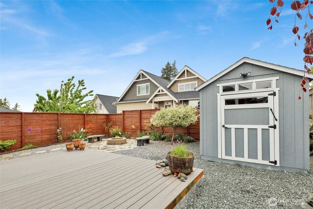 6068 Monument Dr, Ferndale, WA 98248 - wooden deck featuring a storage shed, a fenced backyard, and an outbuilding