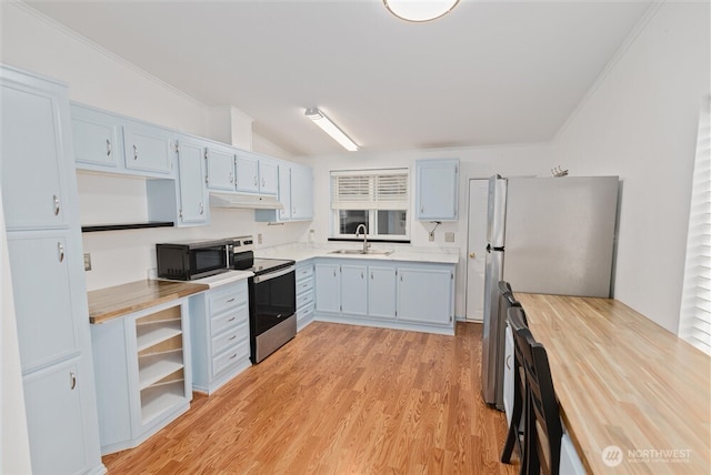 1101 S Scheuber Rd # 27, Centralia, WA 98531 - kitchen with open shelves, appliances with stainless steel finishes, a sink, light wood-style floors, and under cabinet range hood