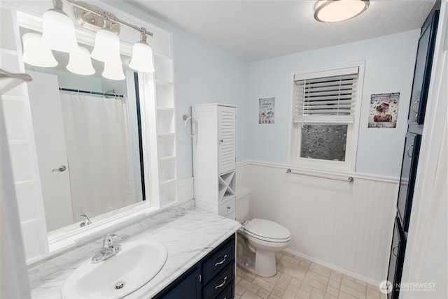 1101 S Scheuber Rd # 27, Centralia, WA 98531 - bathroom with a wainscoted wall, vanity, toilet, and curtained shower