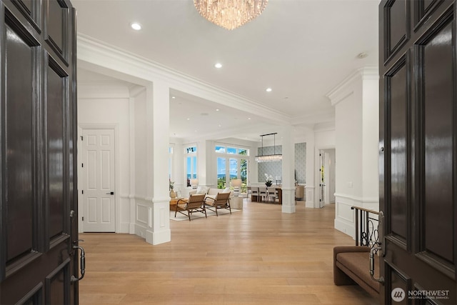 9234 NE 25th St, Clyde Hill, WA 98004 - entryway featuring a decorative wall, light wood-type flooring, a chandelier, crown molding, and wainscoting