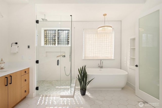 9234 NE 25th St, Clyde Hill, WA 98004 - bathroom with a shower stall, a freestanding bath, tile patterned flooring, and a chandelier