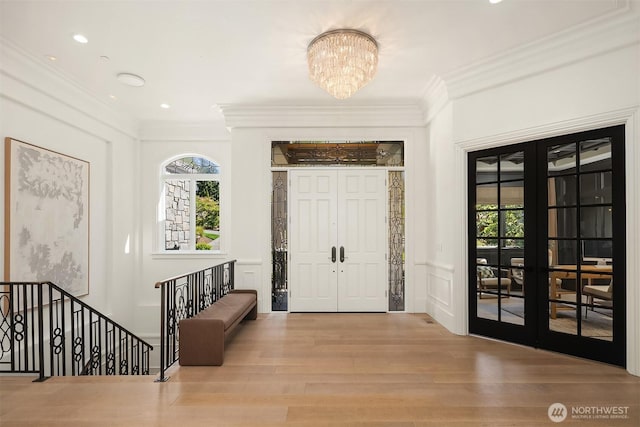 9234 NE 25th St, Clyde Hill, WA 98004 - entrance foyer with french doors, ornamental molding, wood finished floors, a chandelier, and a decorative wall
