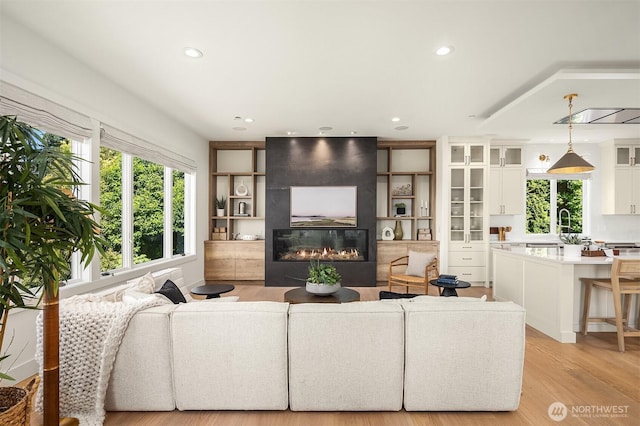 9234 NE 25th St, Clyde Hill, WA 98004 - living room with a fireplace, recessed lighting, and light wood-style floors