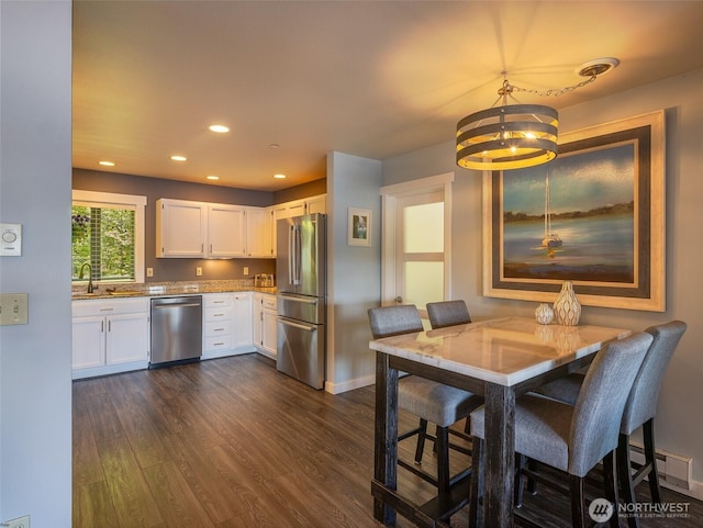 kitchen featuring stainless steel appliances, a chandelier, white cabinets, dark wood-style flooring, and baseboard heating