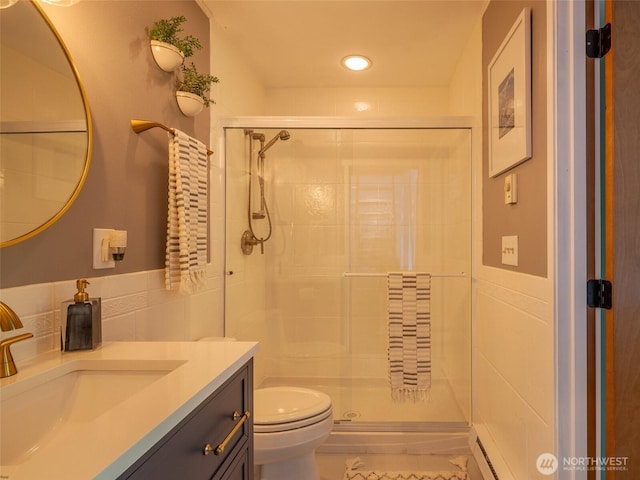 full bathroom with tile walls, a shower stall, toilet, vanity, and baseboard heating