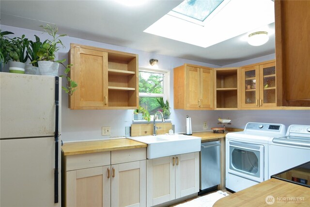 1917 NE 143rd St, Seattle, WA 98125 - kitchen with freestanding refrigerator, open shelves, washer and clothes dryer, stainless steel dishwasher, and a skylight