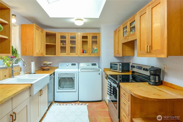 1917 NE 143rd St, Seattle, WA 98125 - laundry area featuring washing machine and clothes dryer, a skylight, and light tile patterned floors