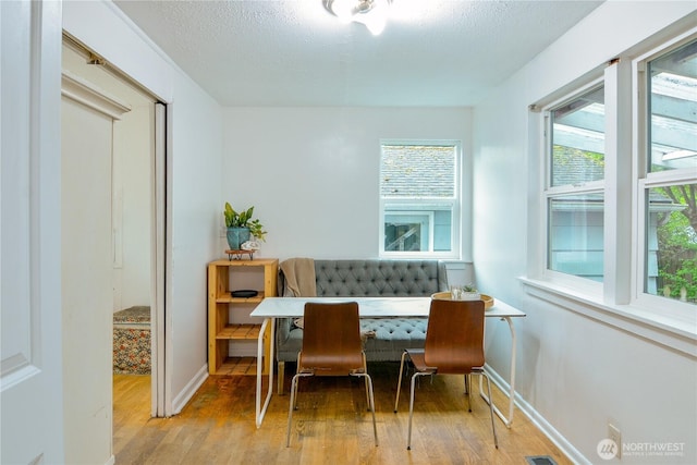 1917 NE 143rd St, Seattle, WA 98125 - dining room featuring hardwood / wood-style flooring, breakfast area, baseboards, and a textured ceiling