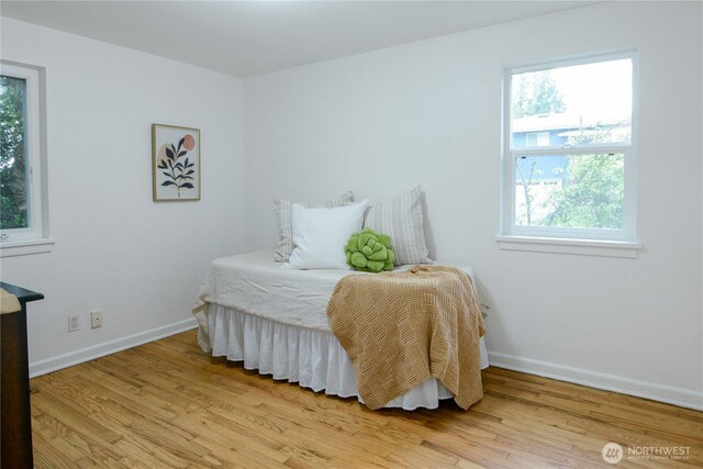 1917 NE 143rd St, Seattle, WA 98125 - bedroom with light wood-style flooring, multiple windows, and baseboards