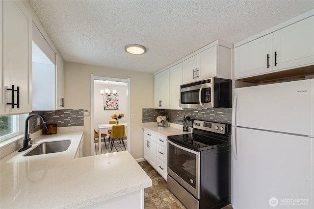 kitchen featuring stainless steel appliances, a sink, white cabinets, backsplash, and a textured ceiling