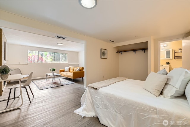 bedroom featuring wood finished floors and baseboards