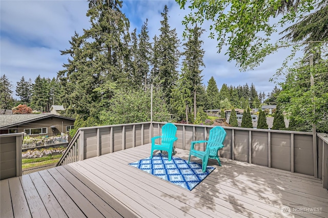 wooden terrace featuring view of wooded area