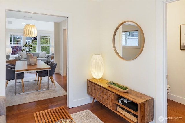 corridor with baseboards and dark wood-style floors