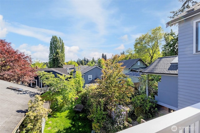 view of side of home featuring a residential view and roof with shingles