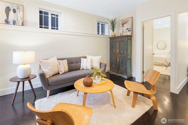living room featuring baseboards and concrete flooring