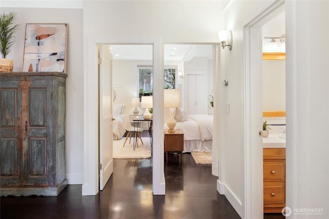 corridor featuring baseboards, concrete flooring, and recessed lighting
