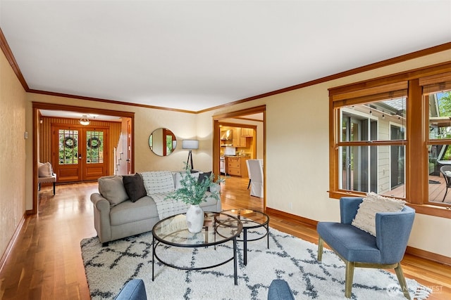 living area featuring wood finished floors, crown molding, and baseboards