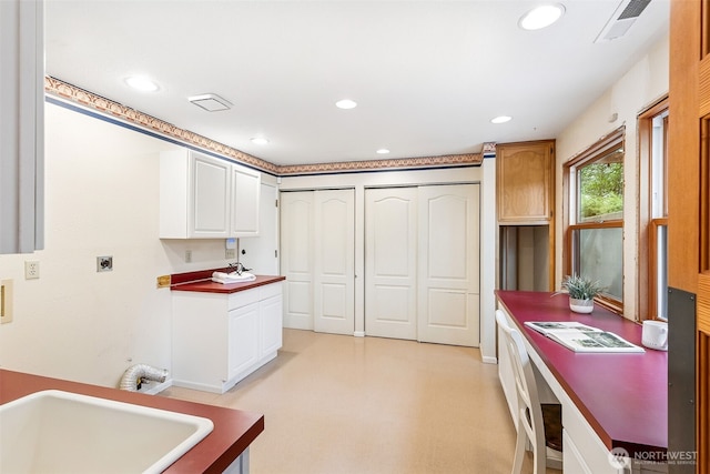 kitchen with recessed lighting, white cabinetry, and a sink