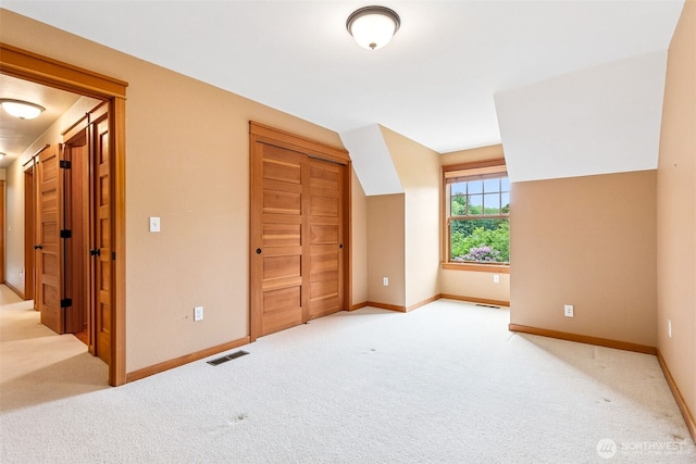 bonus room with light colored carpet and baseboards