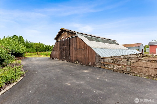 view of barn with fence
