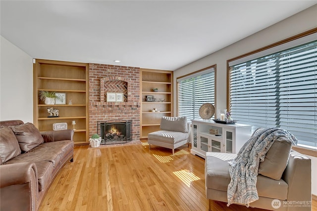 8612 165th Street Ct E, Puyallup, WA 98375 - living area with built in features, wood finished floors, and a fireplace