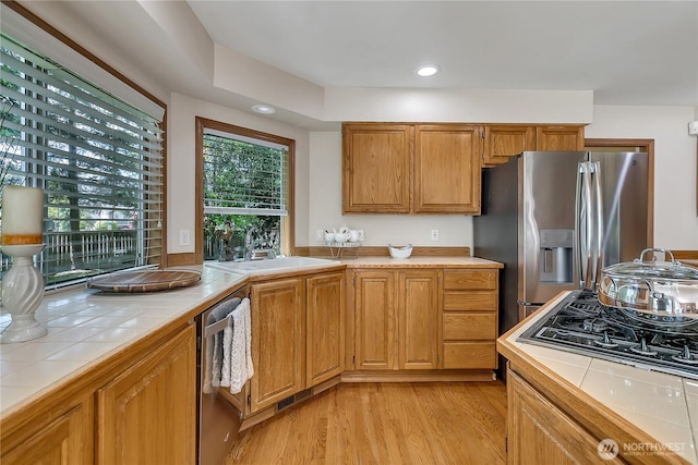 8612 165th Street Ct E, Puyallup, WA 98375 - kitchen featuring tile counters, appliances with stainless steel finishes, a sink, light wood-style floors, and recessed lighting